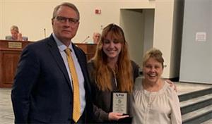 Superintendent, student and teacher with award